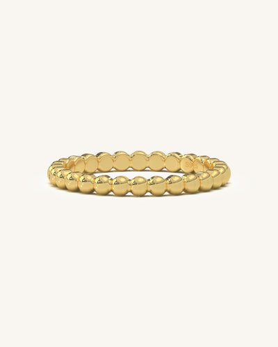 Close-up of a beaded gold vermeil ring on a white background, showcasing its intricate texture and shine.