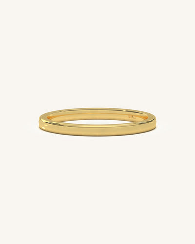 A simple, polished plain gold vermeil sterling silver ring on a neutral background, highlighting its smooth finish.
