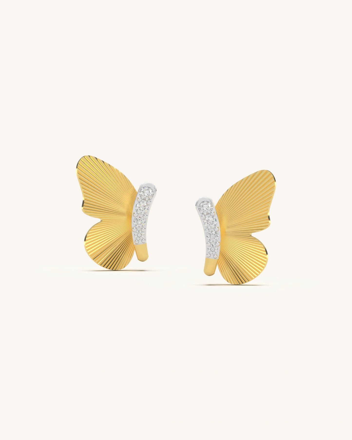 Pair of Skyline Wing Earrings featuring intricate textured 18K gold vermeil wings and a central moissanite cluster on a reflective surface.