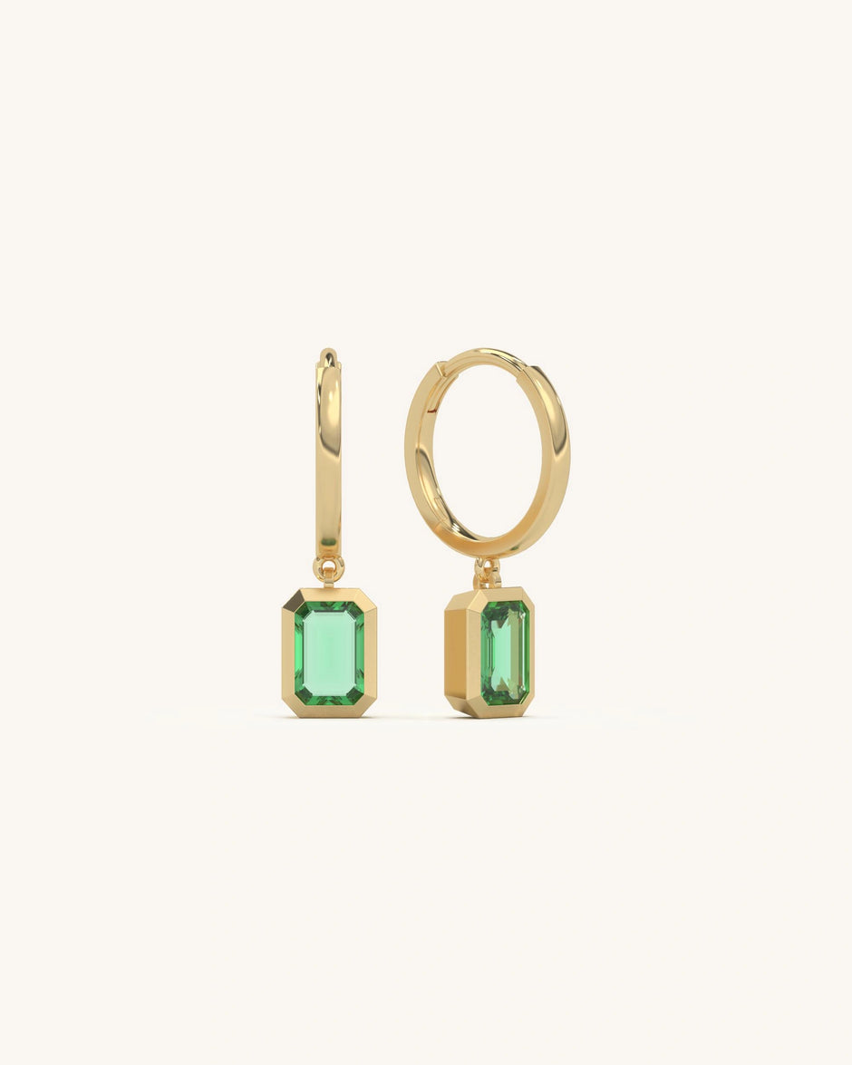 Emerald Charm Hoops in 18KT Gold Vermeil and 925 Sterling Silver, featuring vibrant emerald-cut green stones.