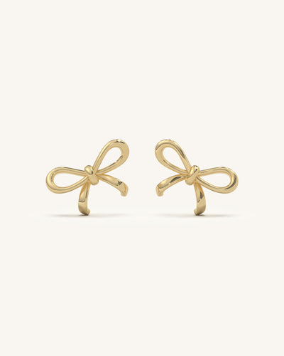 Delicate curved bow drop earrings in 18KT gold vermeil and 925 sterling silver, featuring sparkling moissanite diamonds and a pearl-like accent.