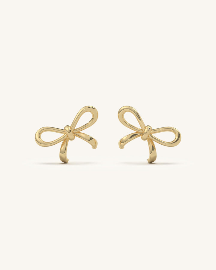 Delicate curved bow drop earrings in 18KT gold vermeil and 925 sterling silver, featuring sparkling moissanite diamonds and a pearl-like accent.